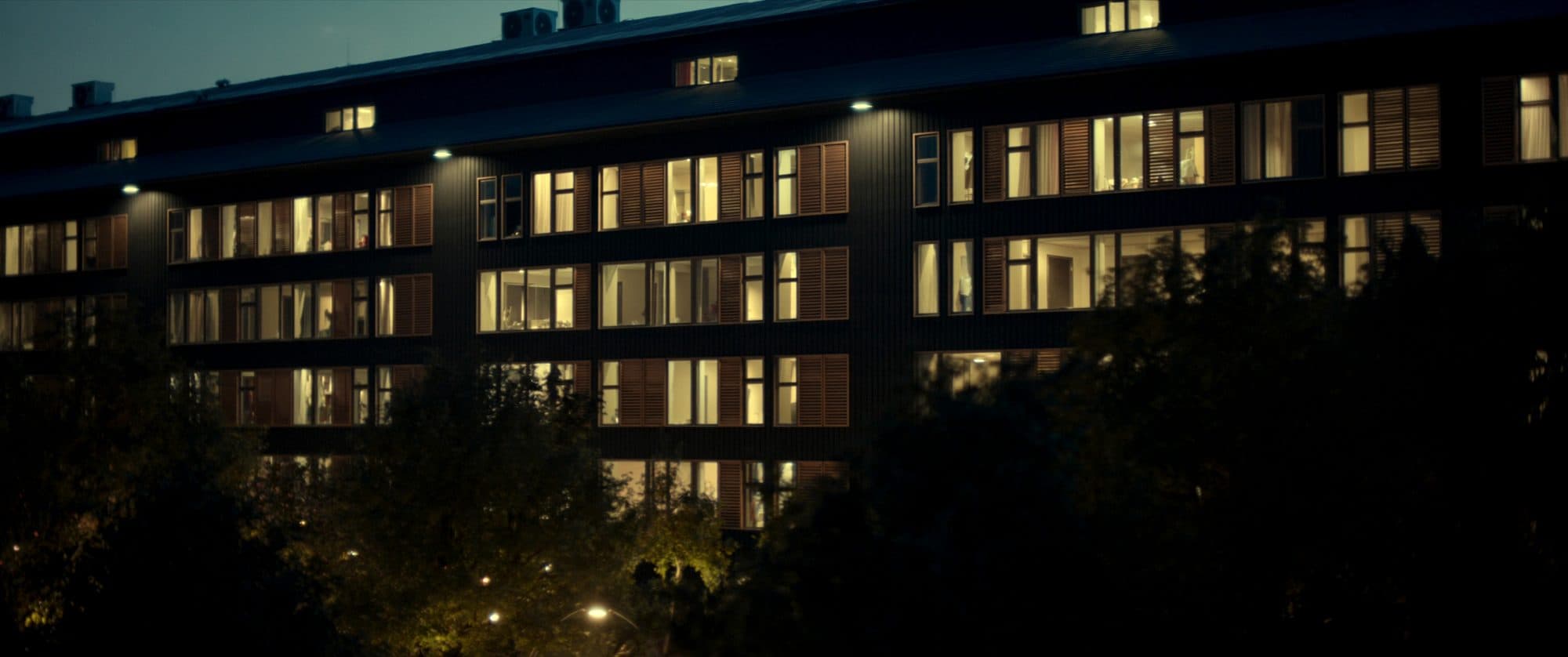 Contemporary multifamily apartment building at golden hour with a landscaped courtyard