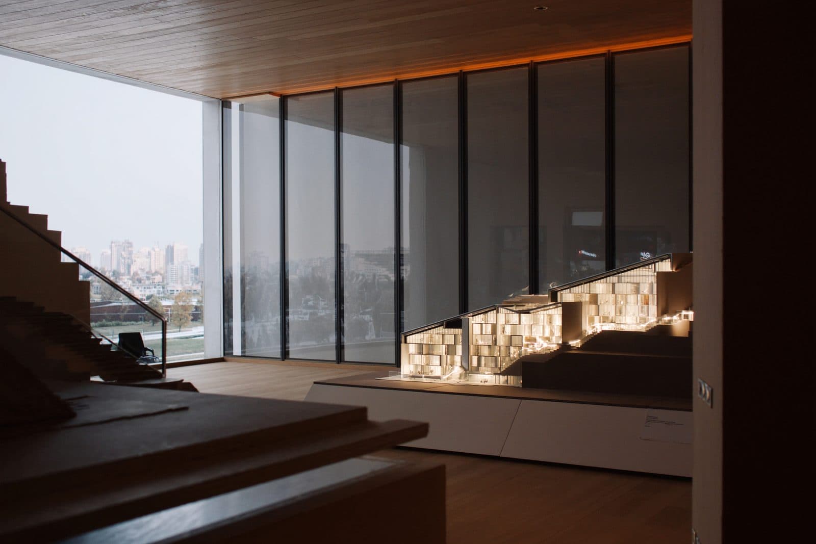 Modern multifamily development leasing gallery with a large site model and floor-to-ceiling glass